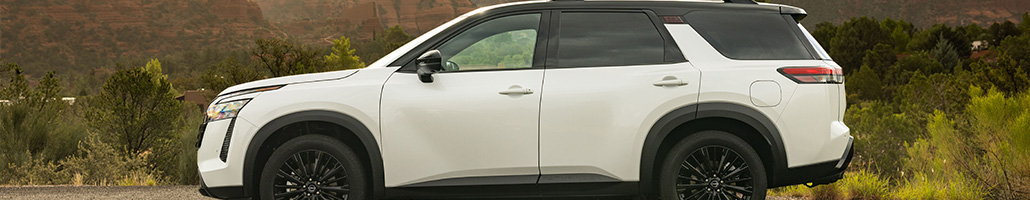 Vue de profil d’un Nissan Pathfinder blanc avec toit noir.